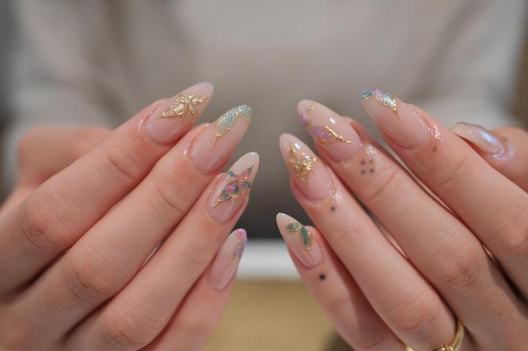 Nude Nägel mit goldenen Schmetterlingen und Marmor-Akzenten